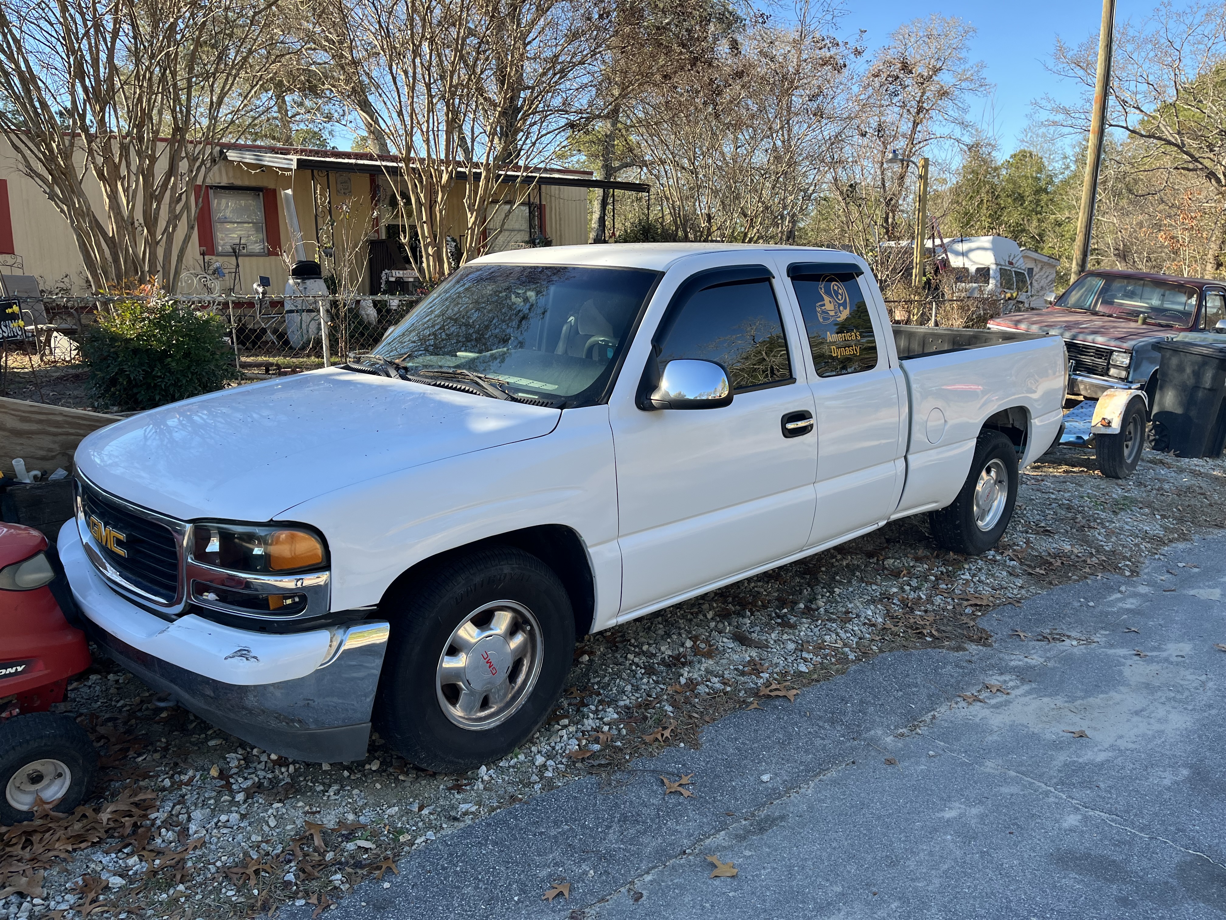 A professional tow truck driver prepares to buy junk cars by loading a damaged vehicle.